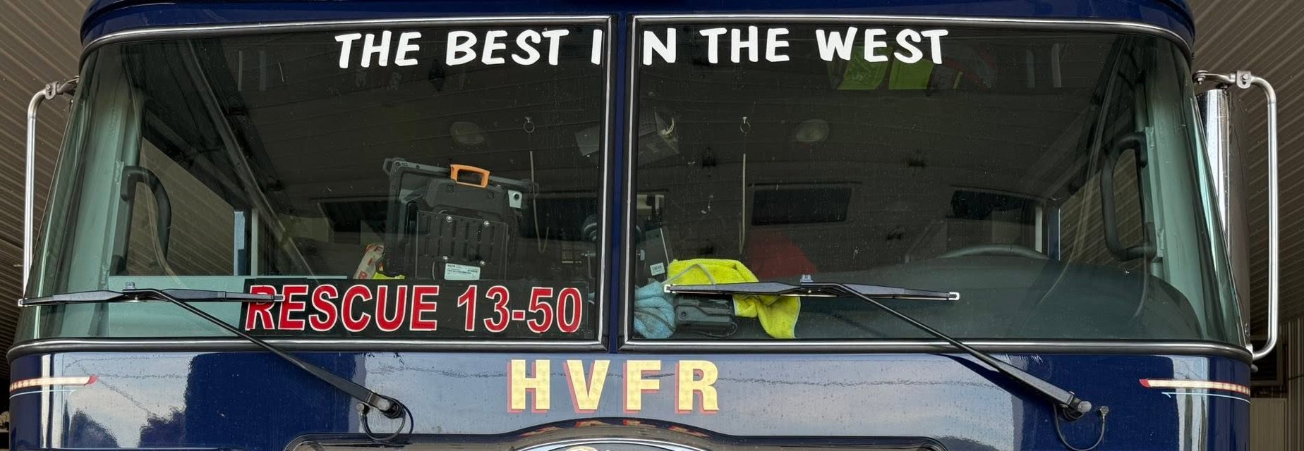 The front of Rescue 13-50, a navy blue Pierce, with THE BEST IN THE WEST across the windshield and HVFR above the grille.