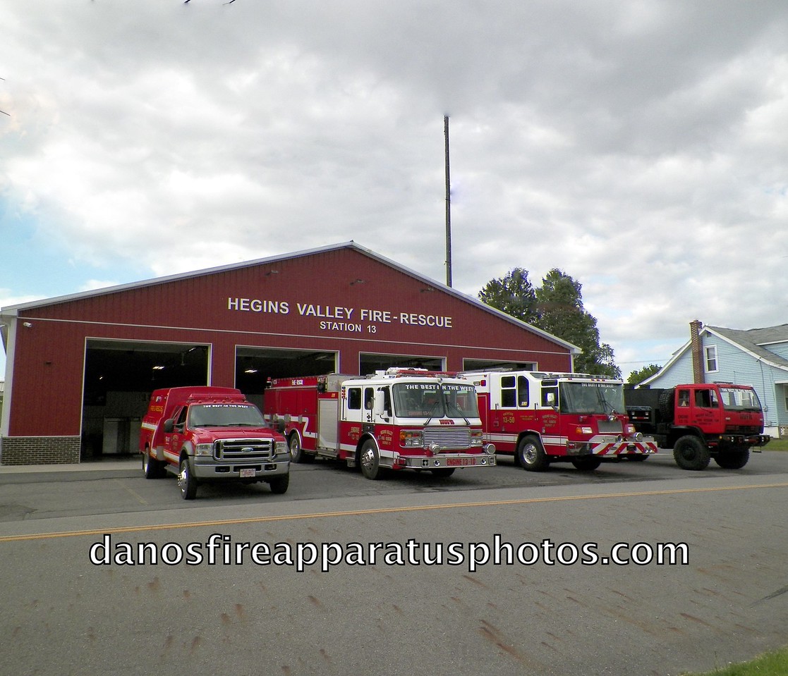 The company's trucks lined up on the apron in front of Station 13 under a cloudy sky.